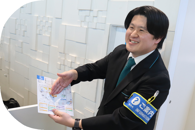 Ｉさんの写真。ご案内カウンターで、パンフレットで案内をしている様子