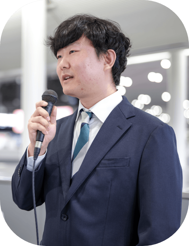 男性がマイクを持ちアナウンスしている