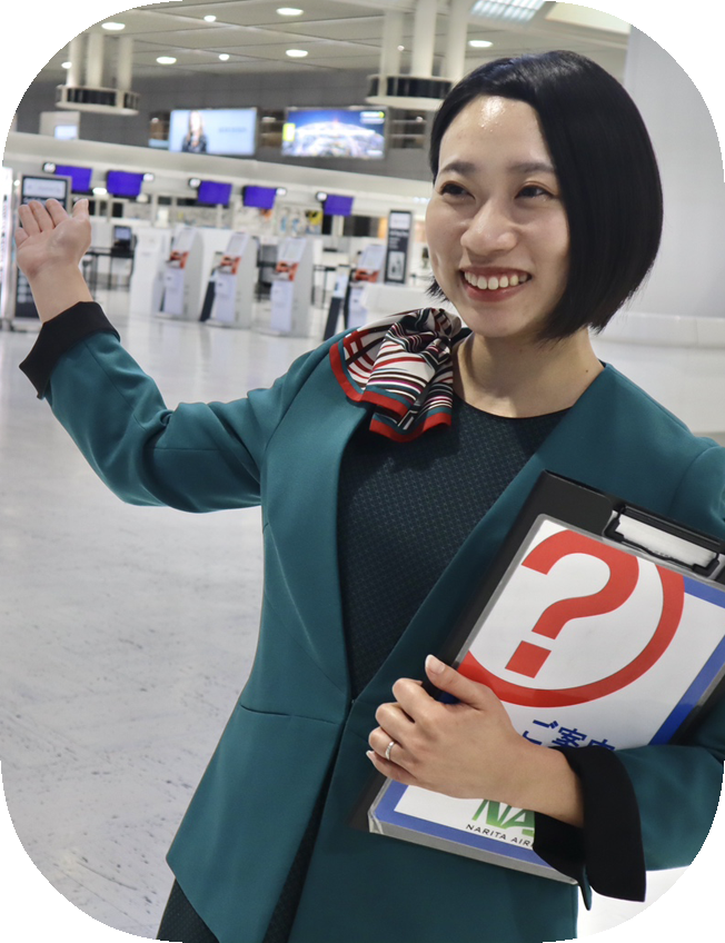 ロビーでバインダーを持って案内している様子