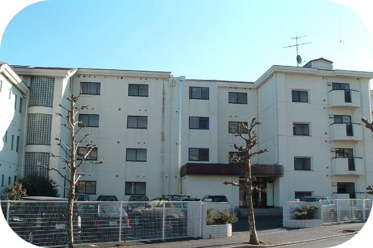 社員寮の写真。白い5階建ての建物