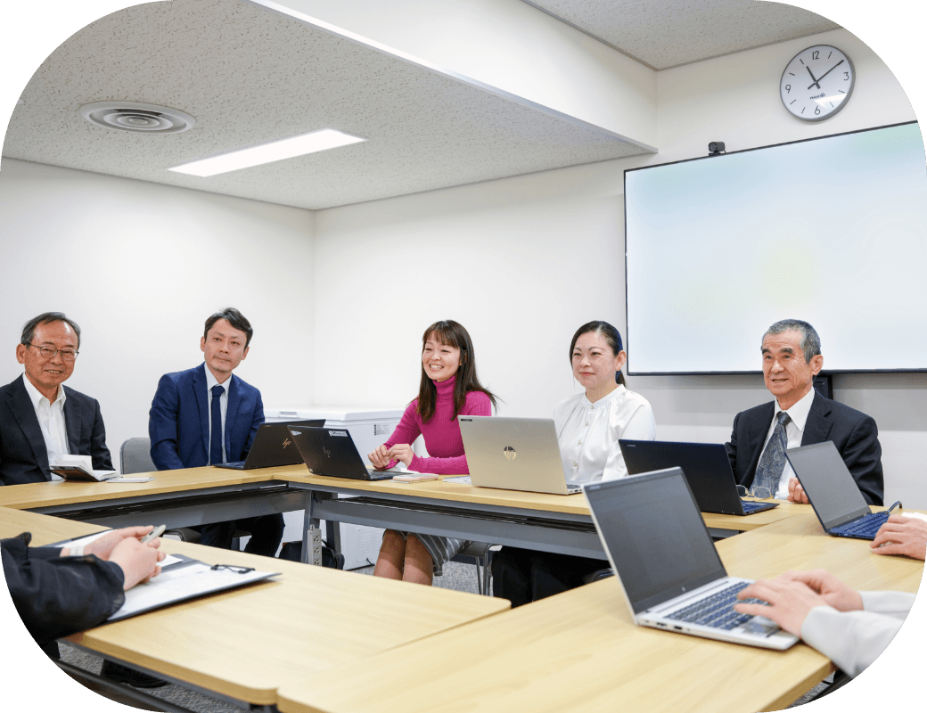 男女5人が机を囲み、和気あいあいと会議をしている様子