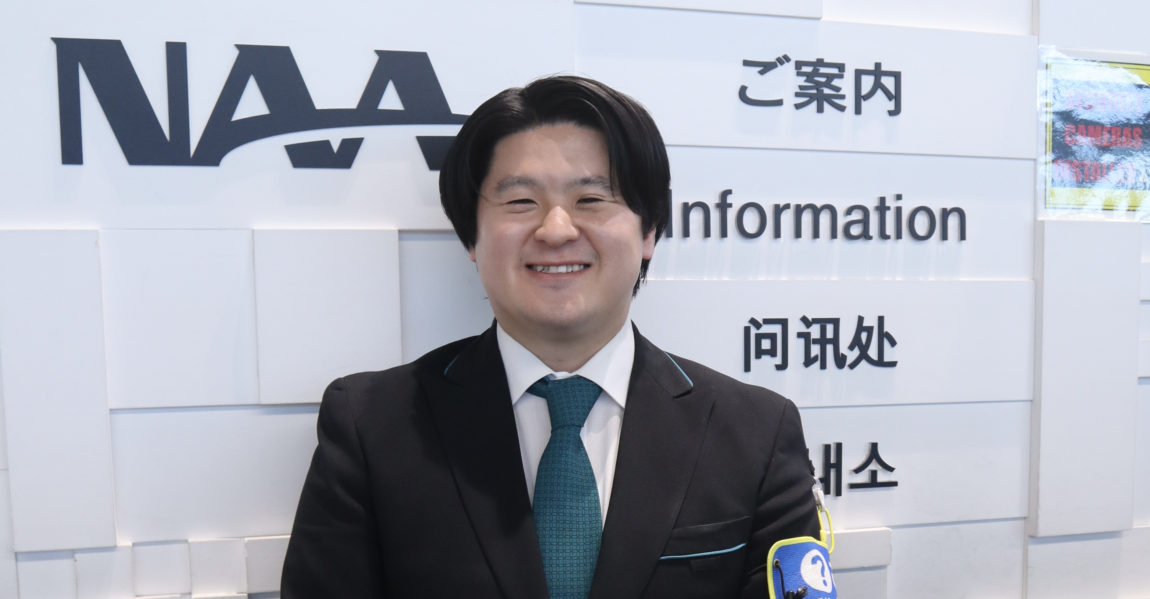 ご案内カウンターにて、男性が笑顔でいる様子
