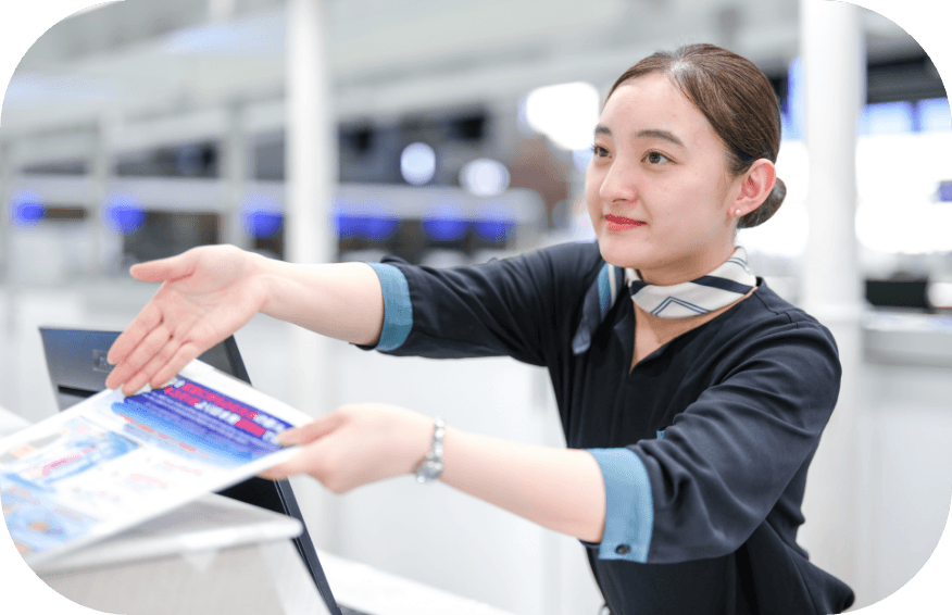 チェックインカウンターで笑顔で案内している女性