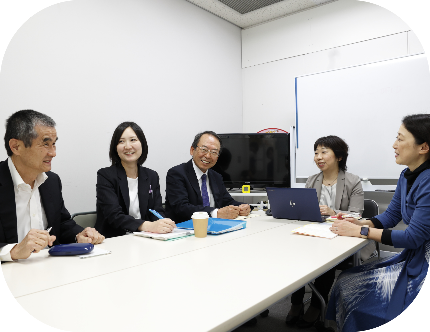 男女5人が机を囲み、和気あいあいと会議をしている様子